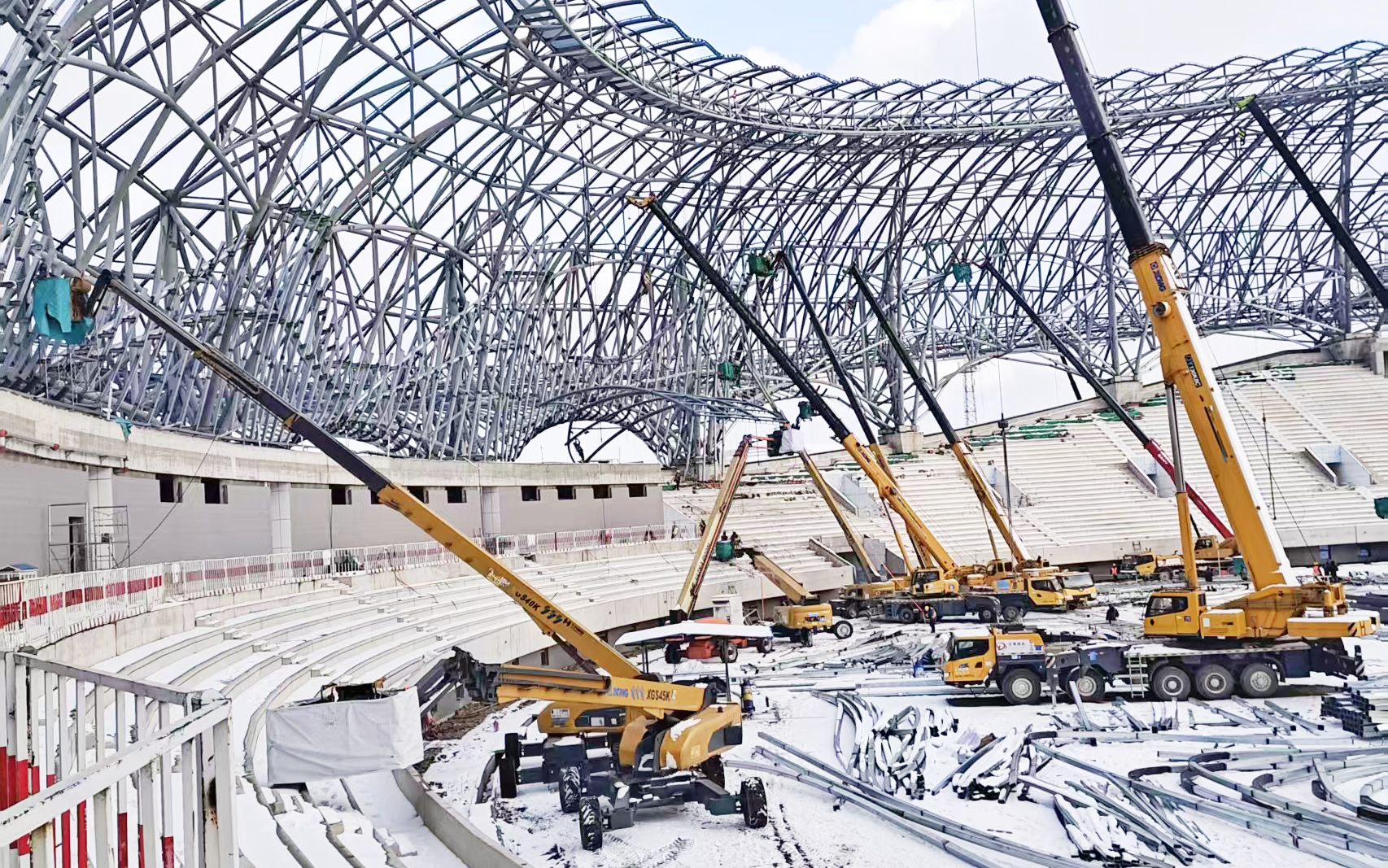 雪天不歇工！16台高米数直臂高空作业平台硬核攻坚蓬莱体育馆项目